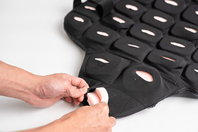 Zoomed in image of hands putting pink foam in the side of the lateral wings.