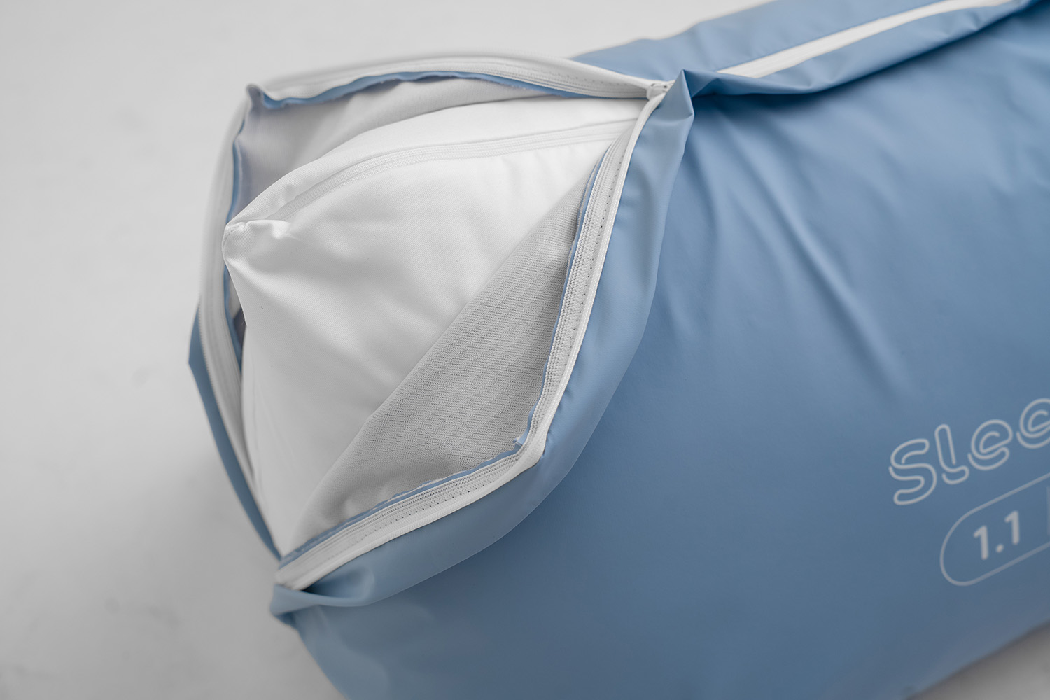 Sleepshape cushion showing the zip on the inner lining to change amount of fill. Shown with a blue cover.